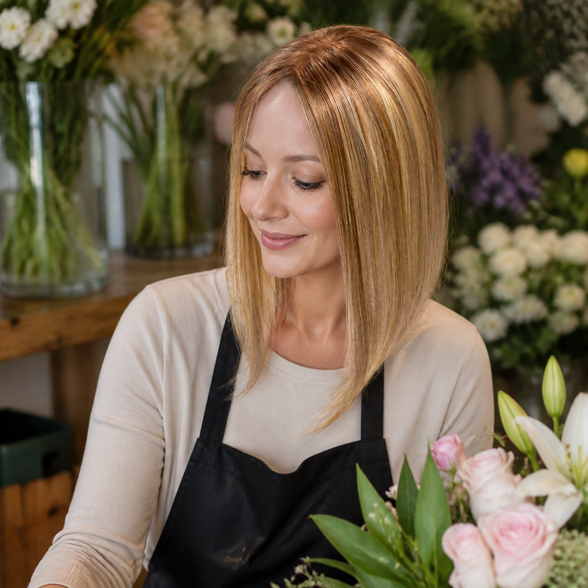 14-inch rooted champagne blonde straight hair topper worn in a flower shop
