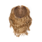 Underside of a 12-inch wavy hair topper showing the base and attachment clips